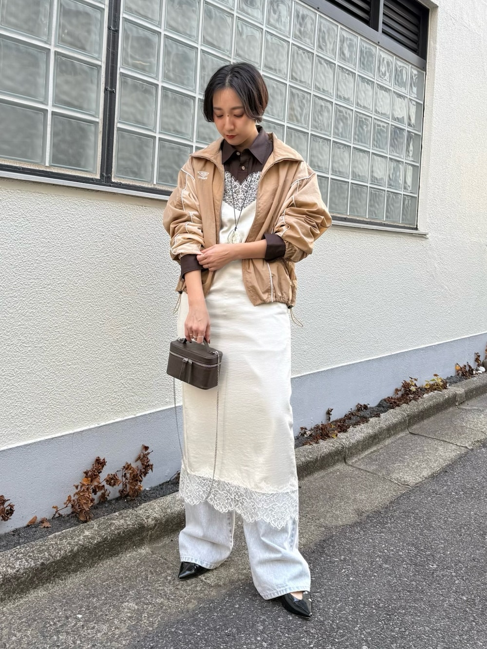 グレー系のデニムパンツ、ブラウン系のショルダーバッグ、ブラウン系のシャツ/ブラウスを着用したレディースの冬コーディネートの1枚目の写真