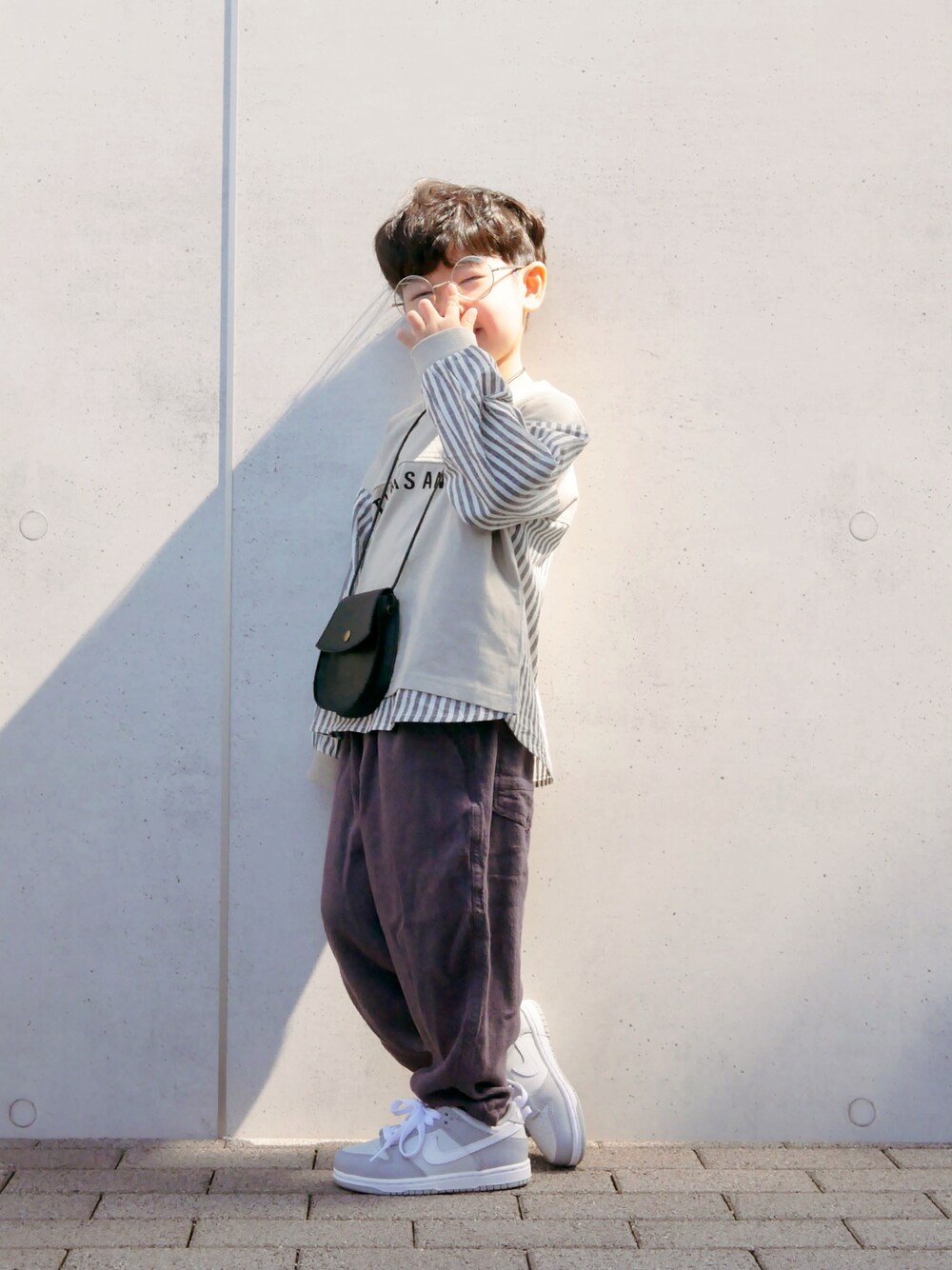 ブラウン系のTシャツ/カットソー、ブラック系のその他パンツ、シルバー系のスニーカーを着用したキッズの春コーディネートの1枚目の写真