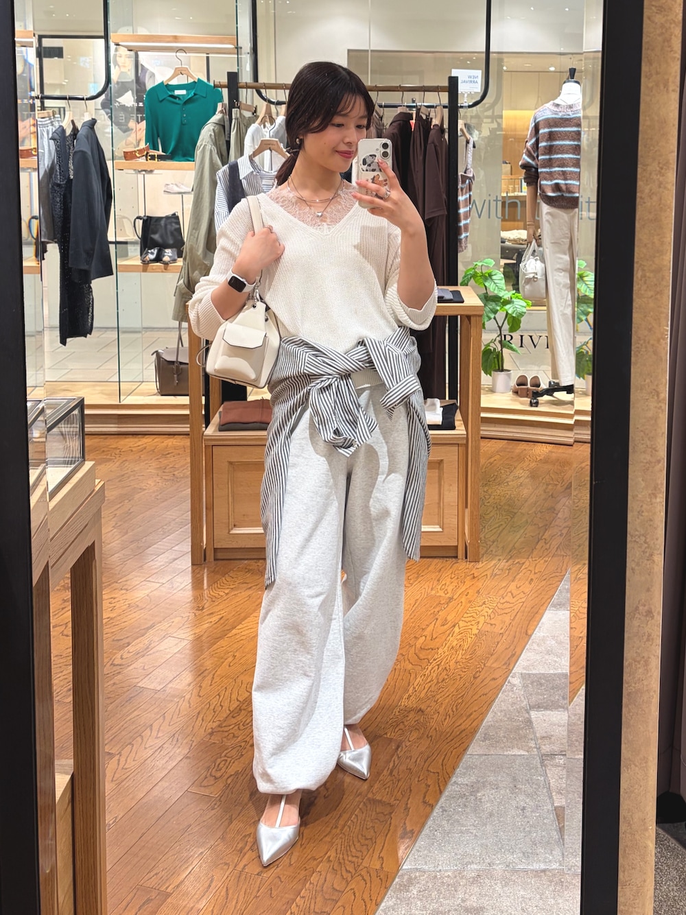 グレー系のスウェットパンツ、シルバー系のその他シューズ、ホワイト系のニット/セーターを着用したレディースの春コーディネートの1枚目の写真