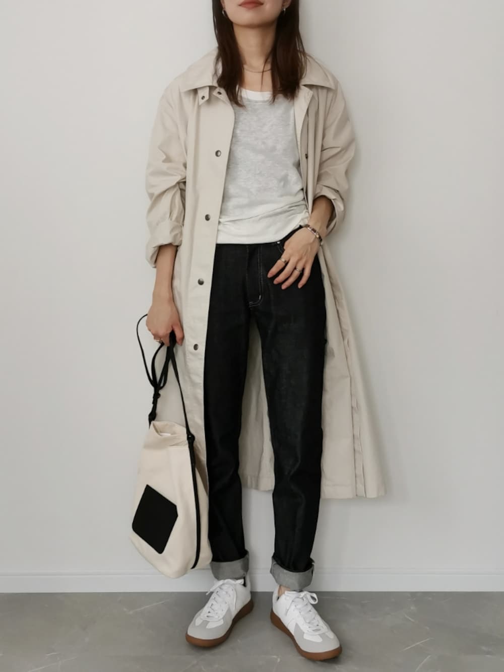 ブラック系のデニムパンツ、ホワイト系のショルダーバッグ、ホワイト系のTシャツ/カットソーを着用したレディースの秋コーディネートの1枚目の写真