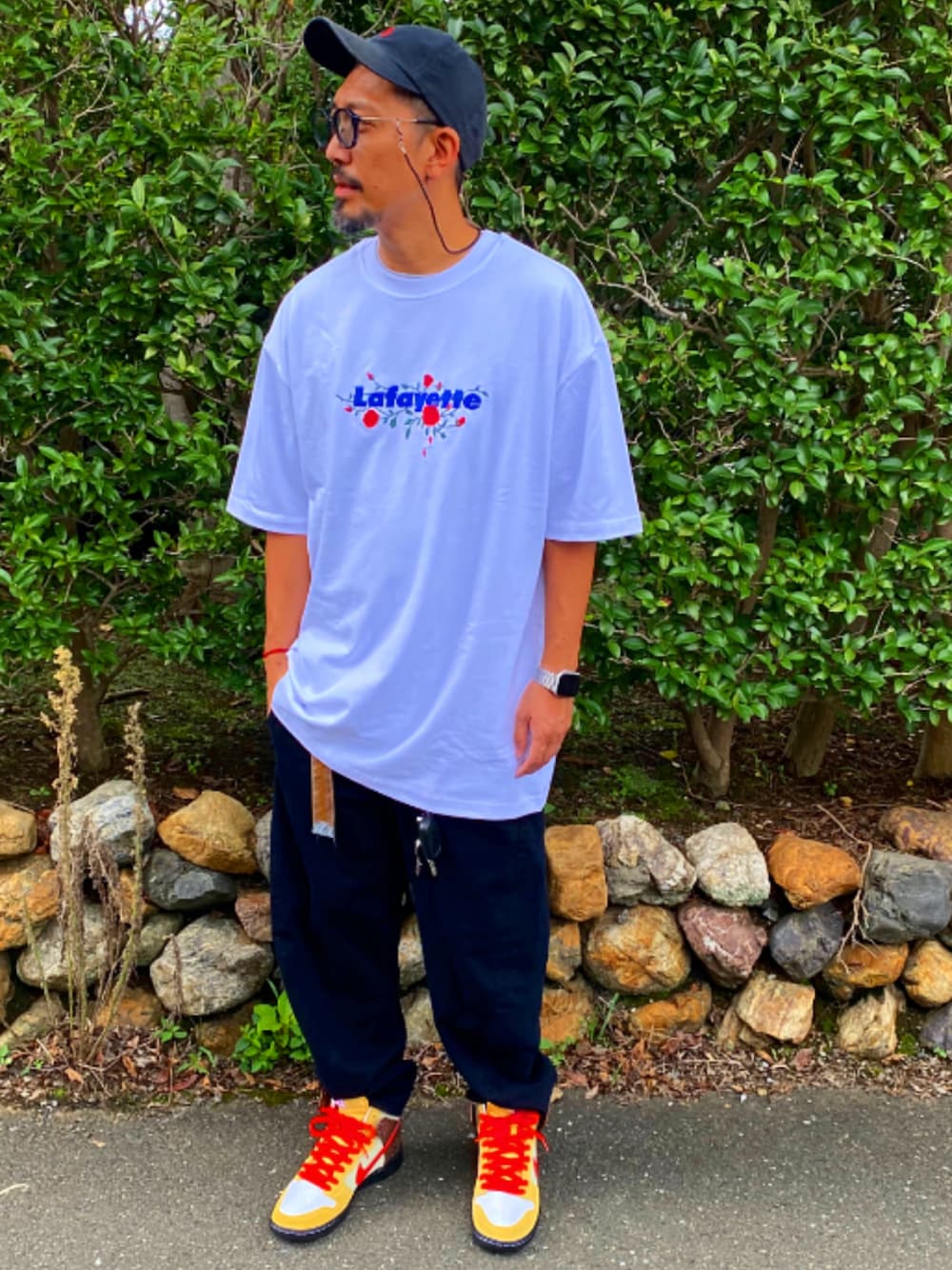 ホワイト系のTシャツ/カットソー、ブラック系のデニムパンツ、ベージュ系のスニーカーを着用したメンズの秋コーディネートの1枚目の写真