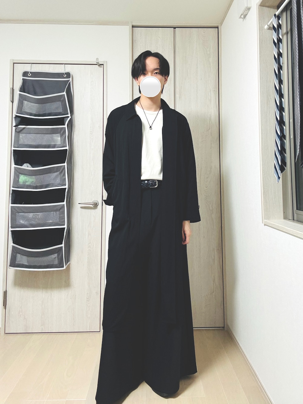 グレー系のTシャツ/カットソー、ブラック系のスラックス、ブラック系のステンカラーコートを着用したメンズの秋コーディネートの1枚目の写真