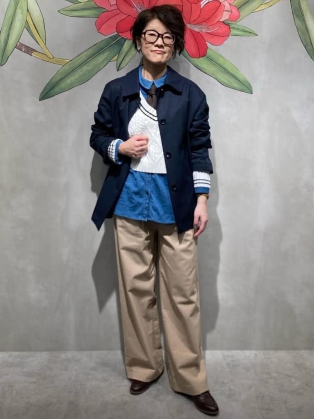 ベージュ系のチノパンツ、ブルー系のシャツ/ブラウス、ホワイト系のニット/セーターを着用したレディースの春コーディネートの1枚目の写真
