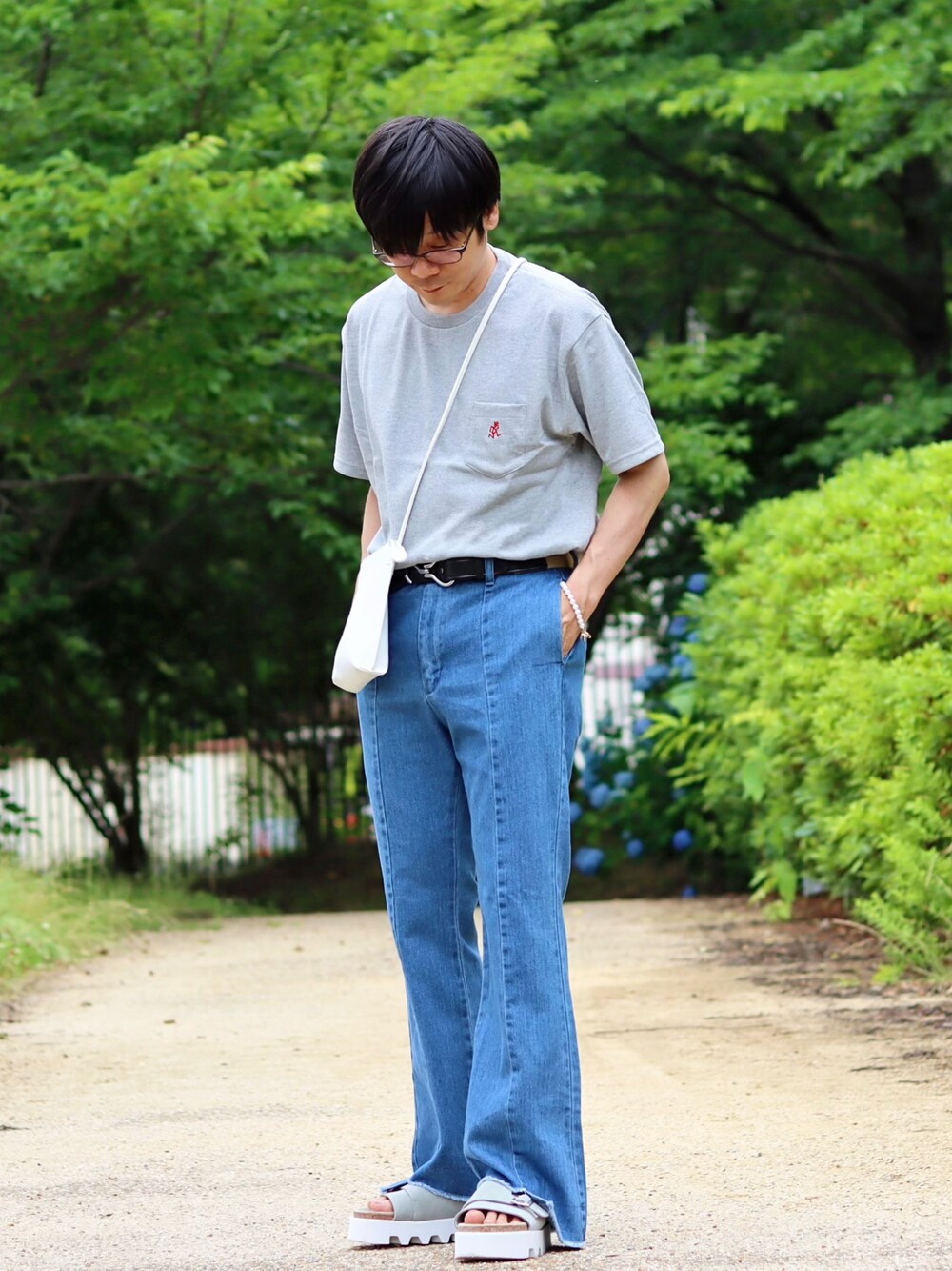 グレー系のTシャツ/カットソー、ブルー系のデニムパンツ、ブルー系のサンダルを着用したメンズの夏コーディネートの1枚目の写真