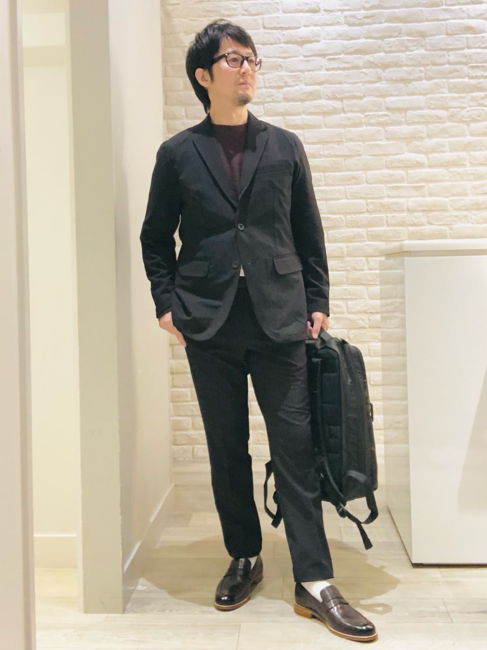 ブラック系のテーラードジャケット、ブラック系のセットアップ、ブラック系のTシャツ/カットソーを着用したメンズの秋コーディネートの1枚目の写真