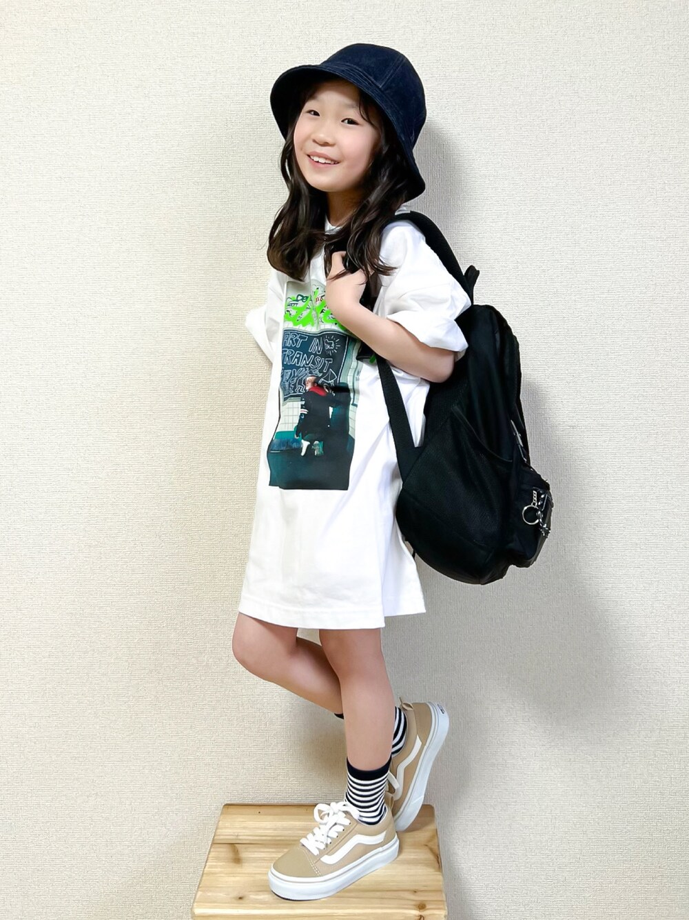 ホワイト系のTシャツ/カットソー、ベージュ系のスニーカー、ブラック系のバックパック/リュックを着用したキッズの春コーディネートの1枚目の写真