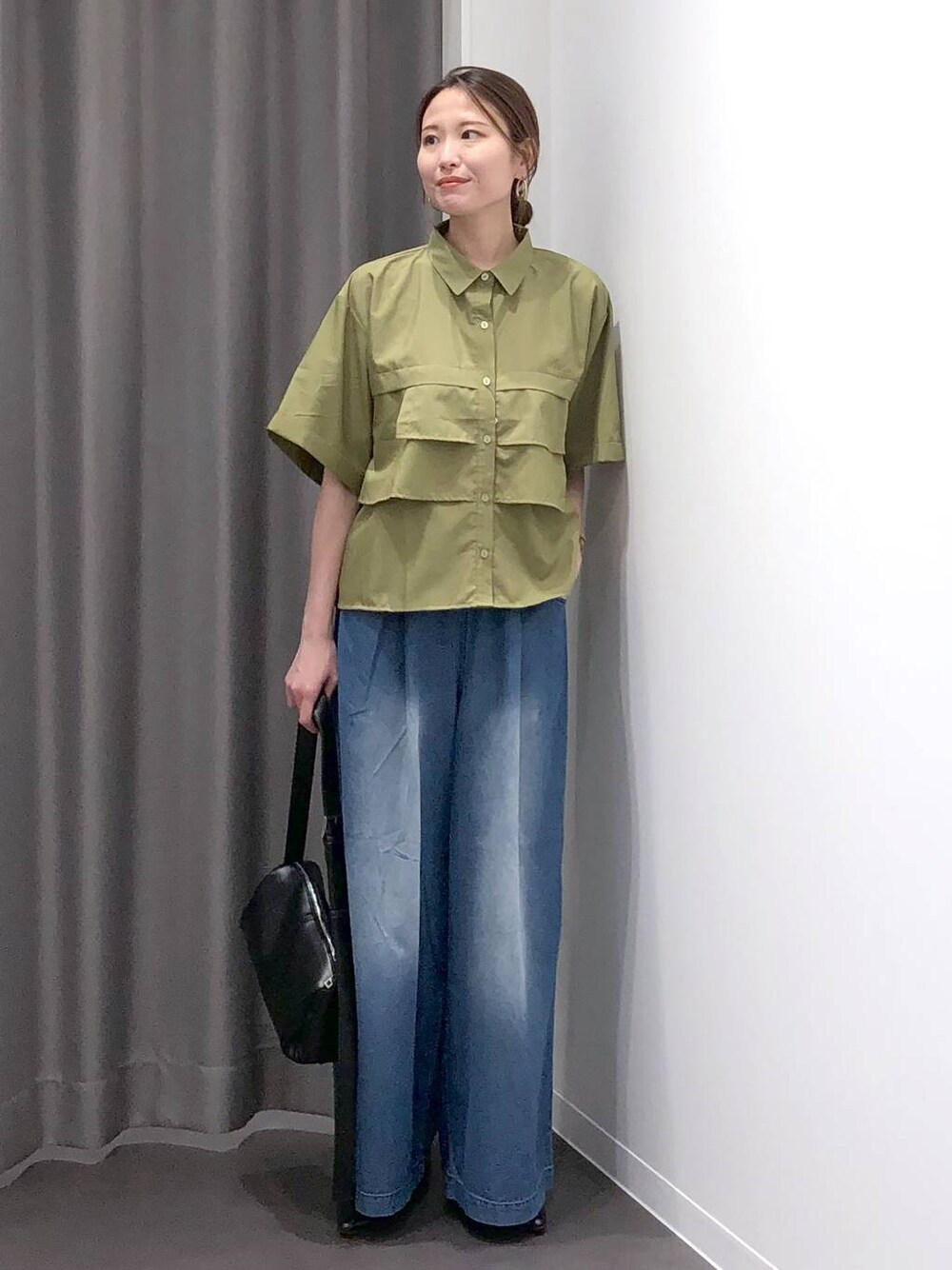ブラック系のパンプス、ブラック系のショルダーバッグ、グリーン系のシャツ/ブラウスを着用したレディースの夏コーディネートの1枚目の写真