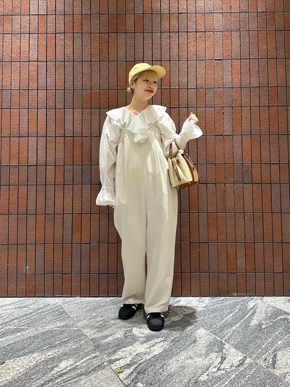 ホワイト系のシャツ/ブラウス、ホワイト系のハンドバッグ、ホワイト系のサロペット/オーバーオールを着用したレディースの春コーディネートの1枚目の写真