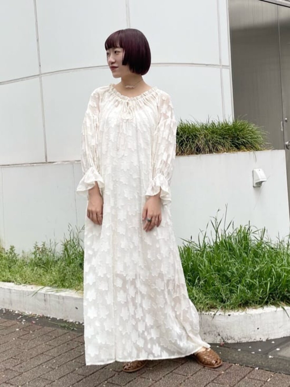 ホワイト系のワンピース、ベージュ系のパンプス、ベージュ系のチョーカーを着用したレディースの春コーディネートの1枚目の写真