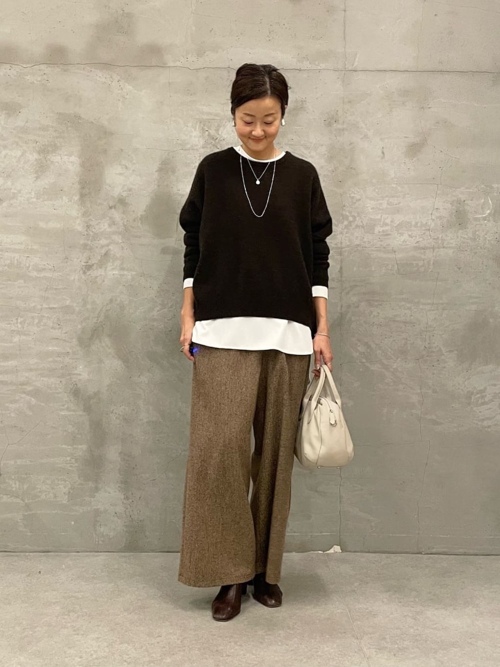 ホワイト系のシャツ/ブラウス、ブラウン系のニット/セーター、ブラウン系のその他パンツを着用したレディースの秋コーディネートの1枚目の写真