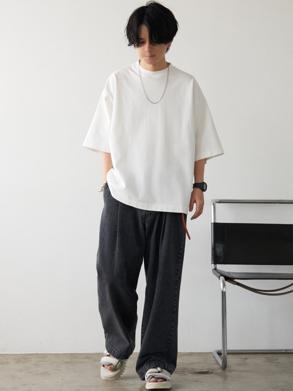 ホワイト系のTシャツ/カットソー、ブラック系のデニムパンツ、ホワイト系のサンダルを着用したメンズの夏コーディネートの1枚目の写真