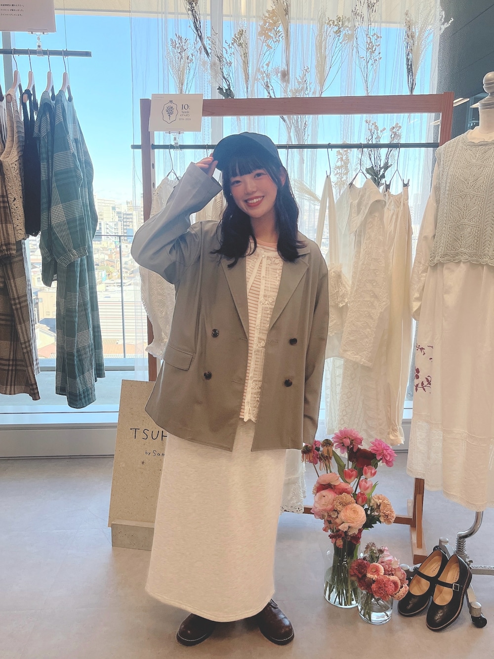 グレー系のスカート、ピンク系のTシャツ/カットソー、グレー系のノーカラージャケットを着用したレディースの冬コーディネートの1枚目の写真
