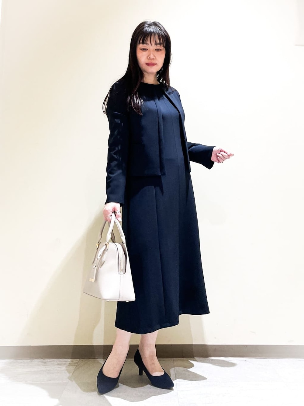 レッド系のノーカラージャケット、ブルー系のワンピース、ブルー系のノーカラージャケットを着用したレディースの春コーディネートの1枚目の写真