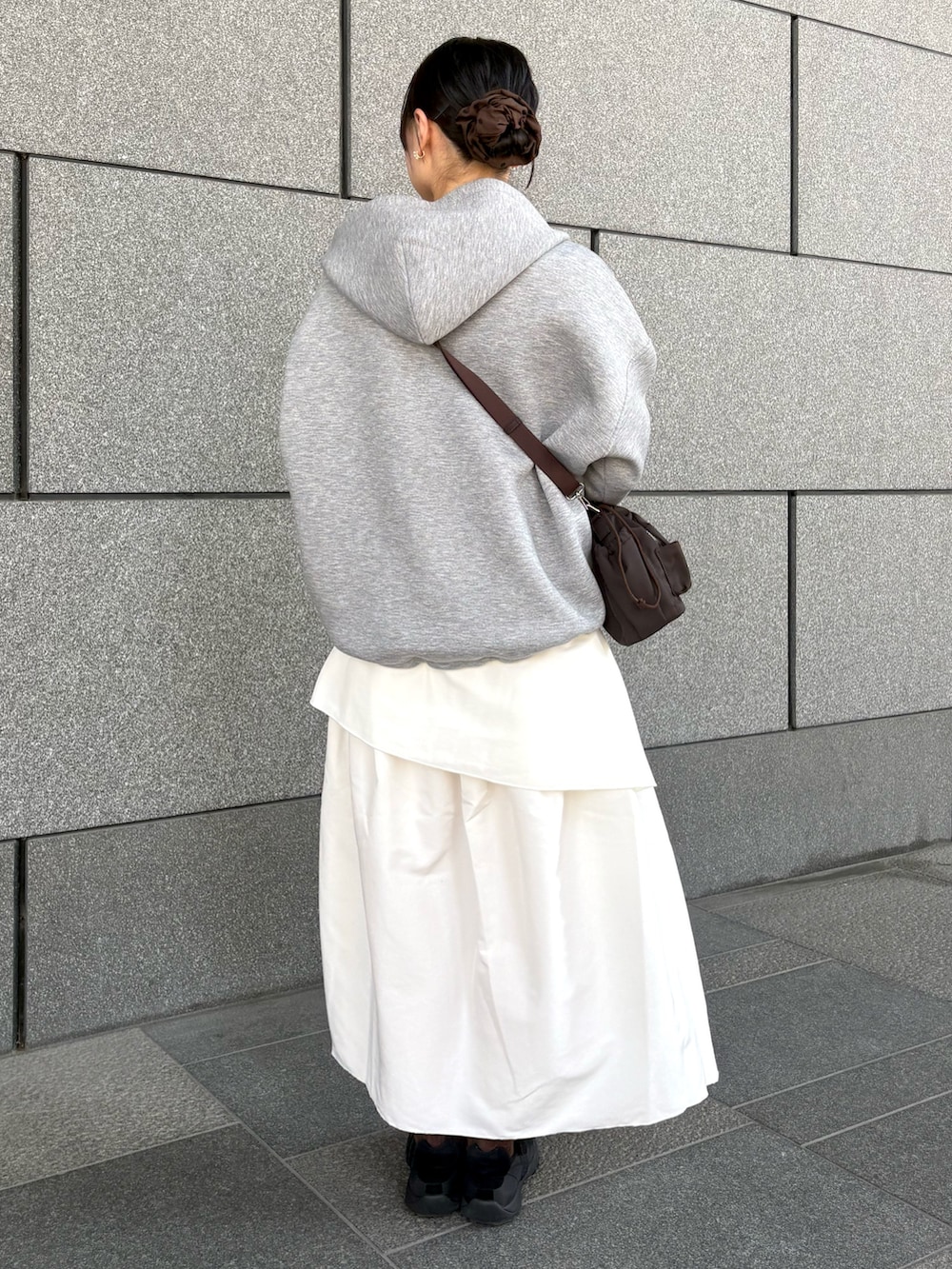 ホワイト系のスカート、グレー系のパーカー、ホワイト系のTシャツ/カットソーを着用したレディースの春コーディネートの3枚目の写真