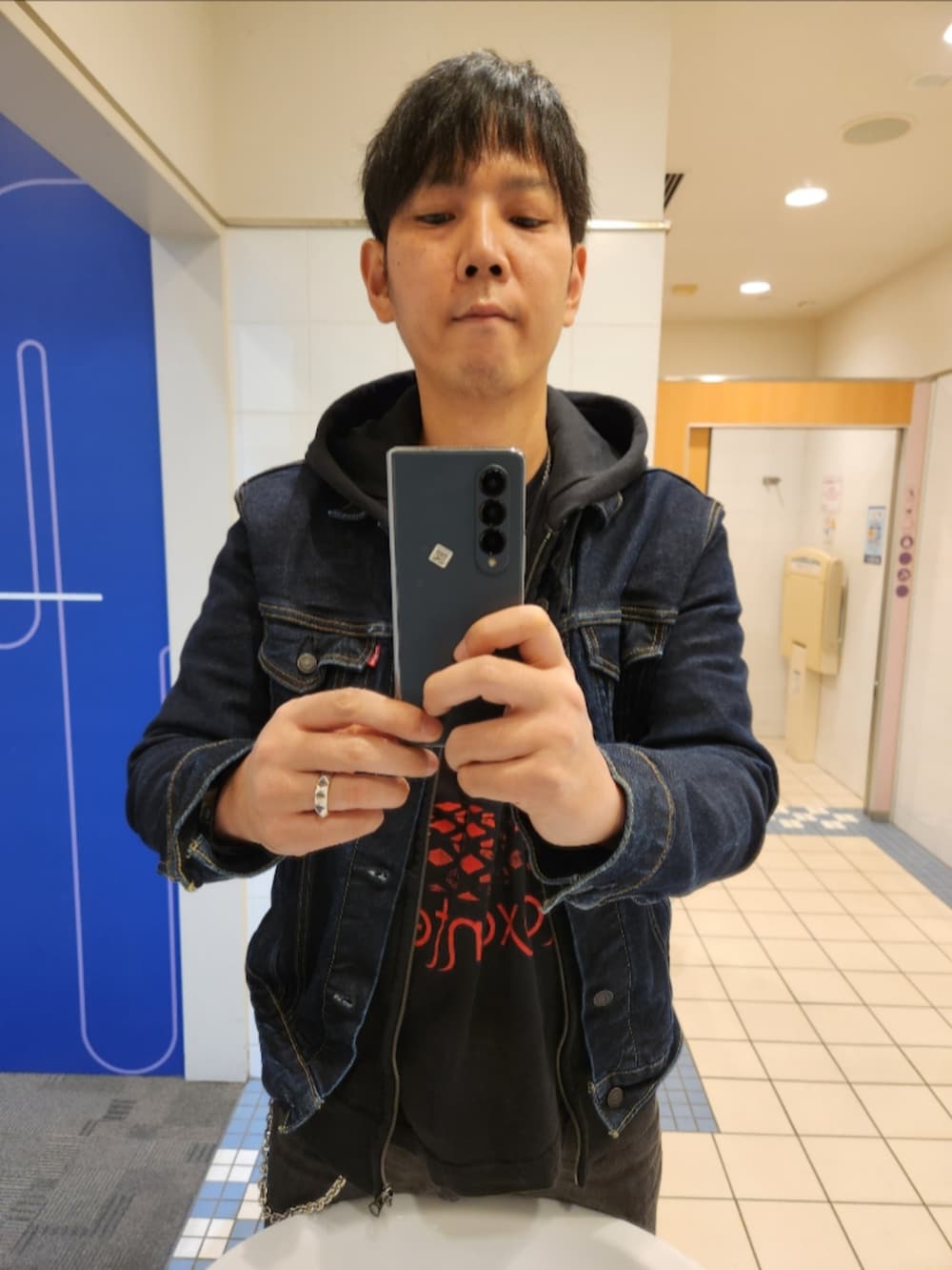 ブルー系のデニムジャケット、ブラック系のパーカー、ブラック系のTシャツ/カットソーを着用したメンズの秋コーディネートの3枚目の写真