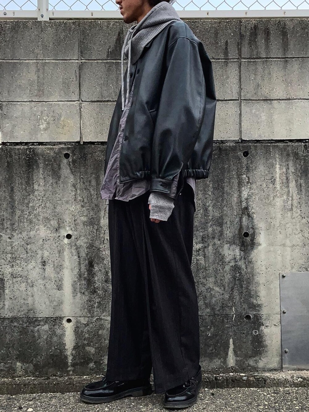 ブラック系のブルゾン、グレー系のシャツ/ブラウス、ブラック系のスラックスを着用したメンズの冬コーディネートの3枚目の写真