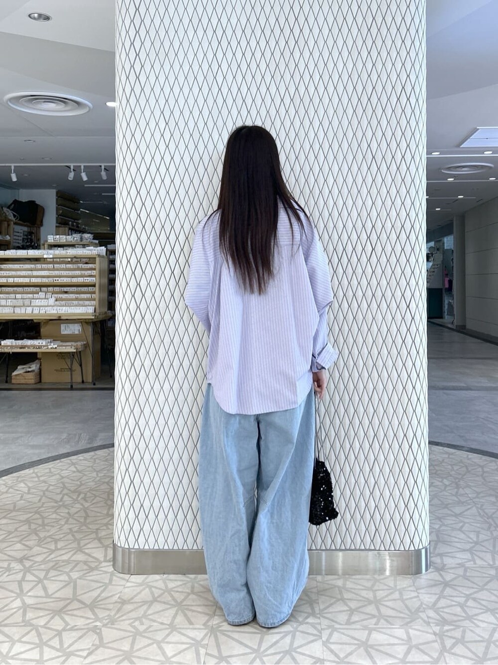 ブルー系のデニムパンツ、グレー系のトレンチコート、ブラック系のショルダーバッグを着用したレディースの春コーディネートの5枚目の写真