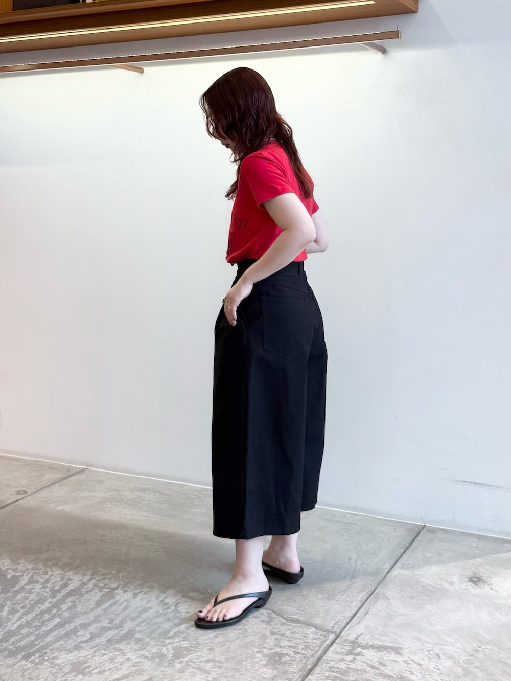 レッド系のTシャツ/カットソー、ブラック系のその他パンツ、ブラック系のサンダルを着用したレディースの夏コーディネートの3枚目の写真