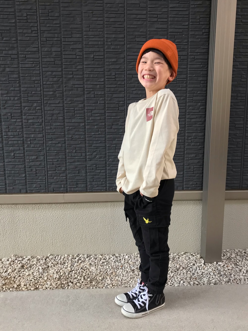 ブラック系のパーカー、ホワイト系のTシャツ/カットソー、ブラック系のカーゴパンツを着用したキッズの春コーディネートの3枚目の写真
