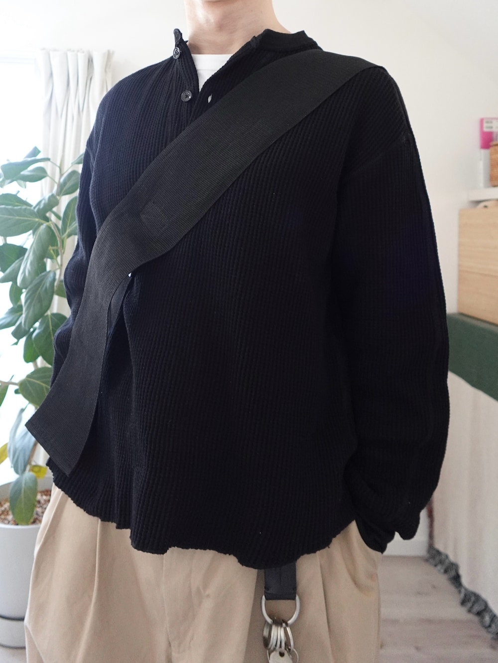 ブラック系のTシャツ/カットソー、ベージュ系のチノパンツ、ブラック系のショルダーバッグを着用したメンズの春コーディネートの4枚目の写真