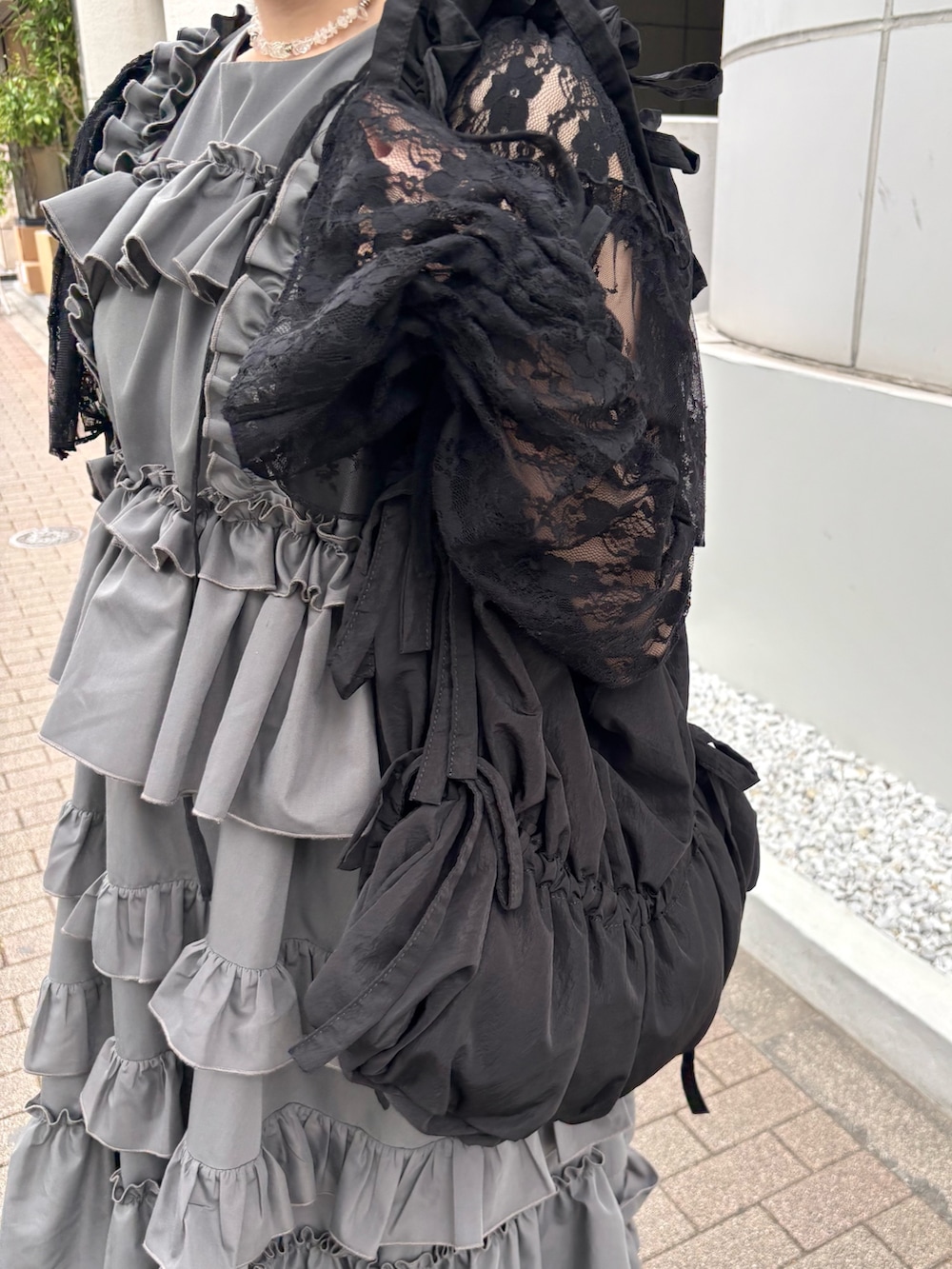 グレー系のワンピース、ブラック系のカーディガン/ボレロ、ブラック系のバレエシューズを着用したレディースの春コーディネートの8枚目の写真