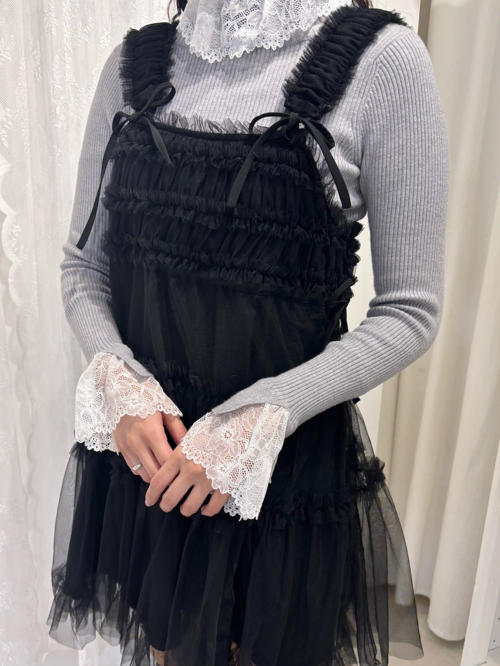 グレー系のニット/セーター、レッド系のショルダーバッグ、ブラック系のワンピースを着用したレディースの秋コーディネートの4枚目の写真