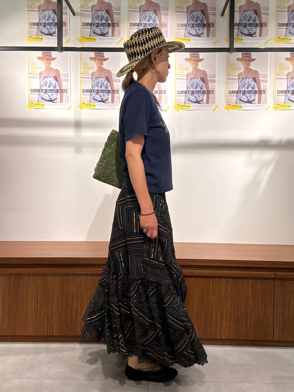 ブラック系のスカート、ブルー系のTシャツ/カットソー、グリーン系のトートバッグを着用したレディースの春コーディネートの2枚目の写真