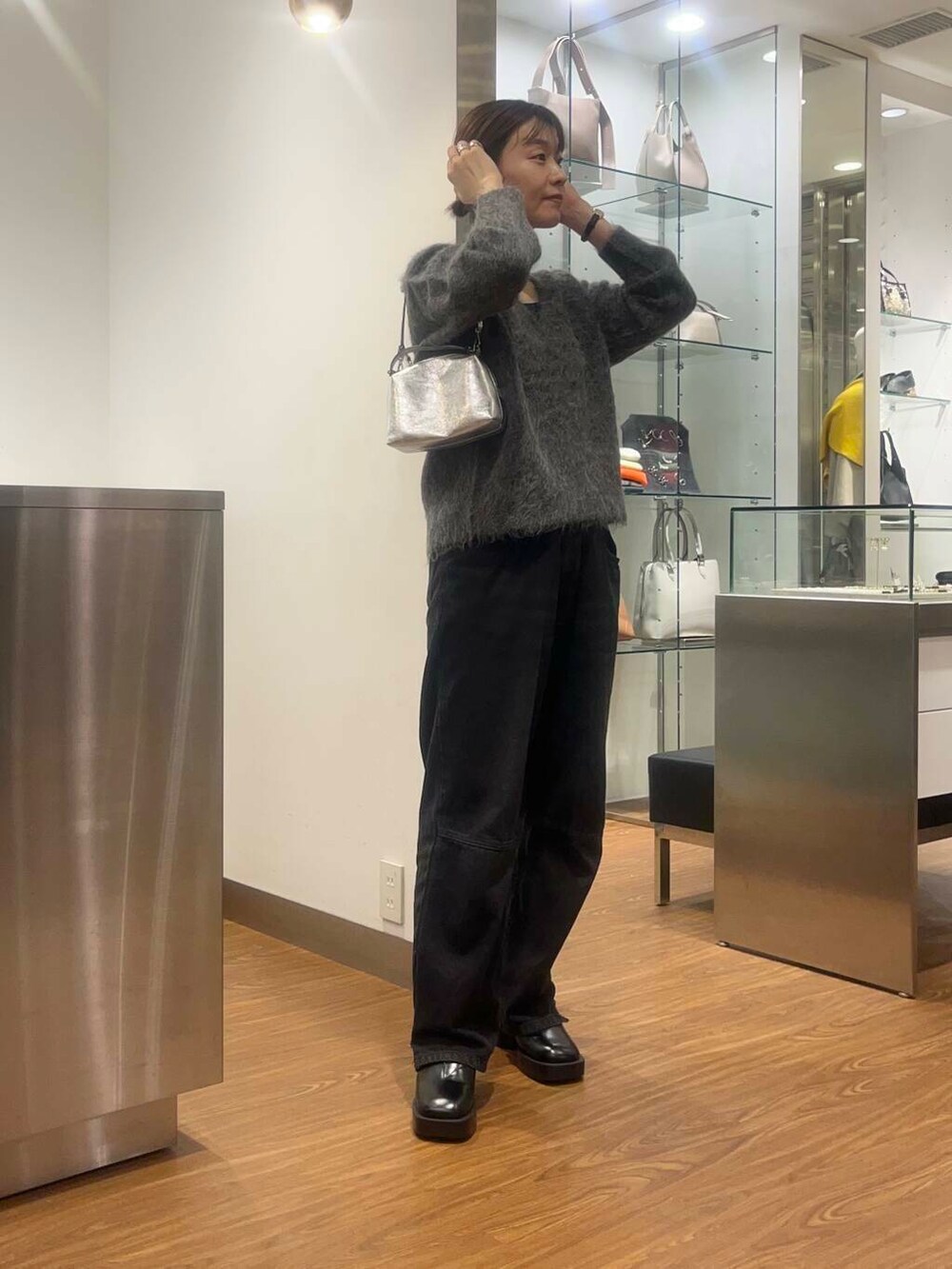 ブラック系のデニムパンツ、グレー系のニット/セーター、ブラック系のその他シューズを着用したレディースの秋コーディネートの3枚目の写真