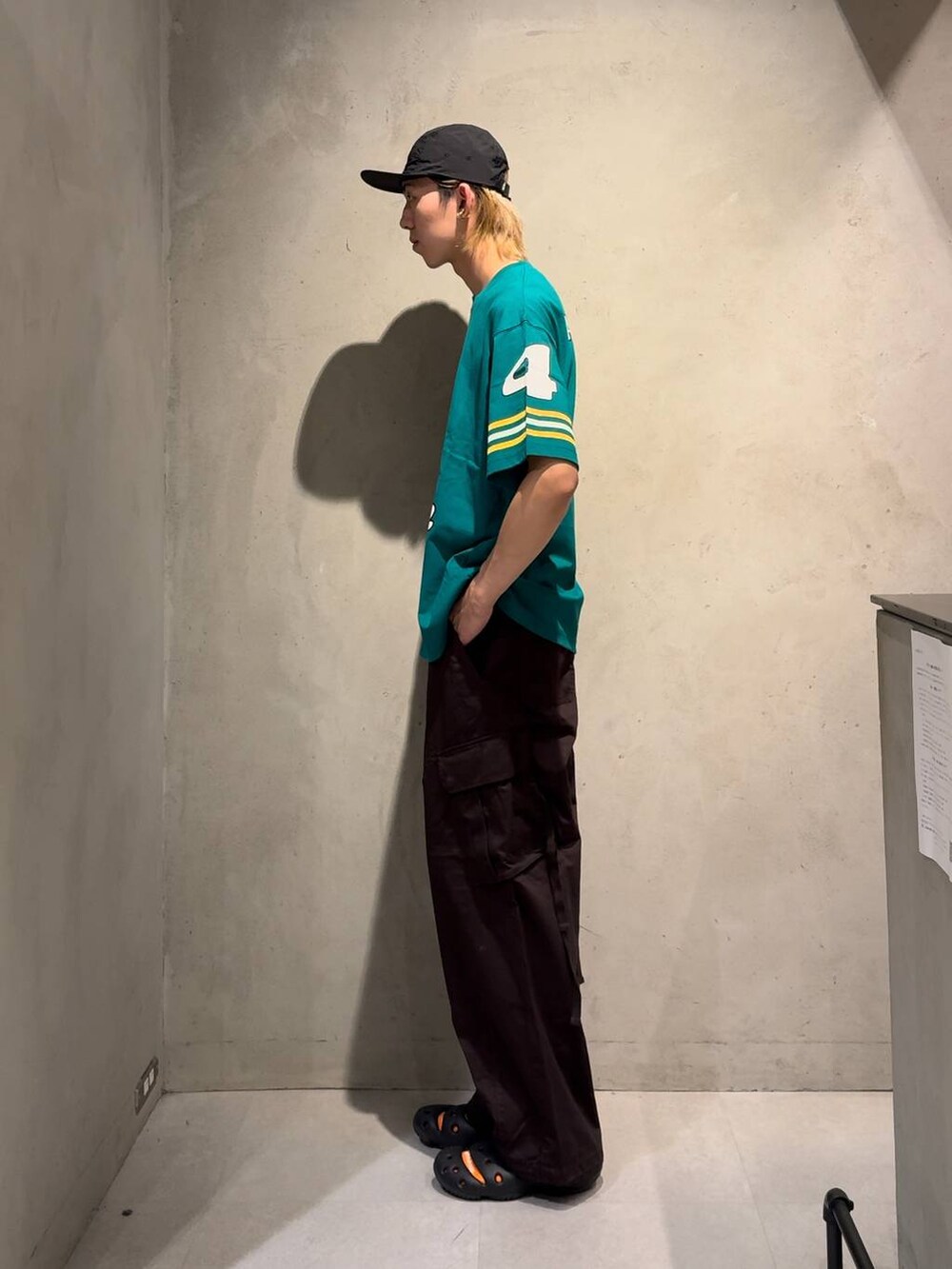 ブラウン系のカーゴパンツ、グリーン系のTシャツ/カットソー、ホワイト系のネックレスを着用したメンズの夏コーディネートの3枚目の写真
