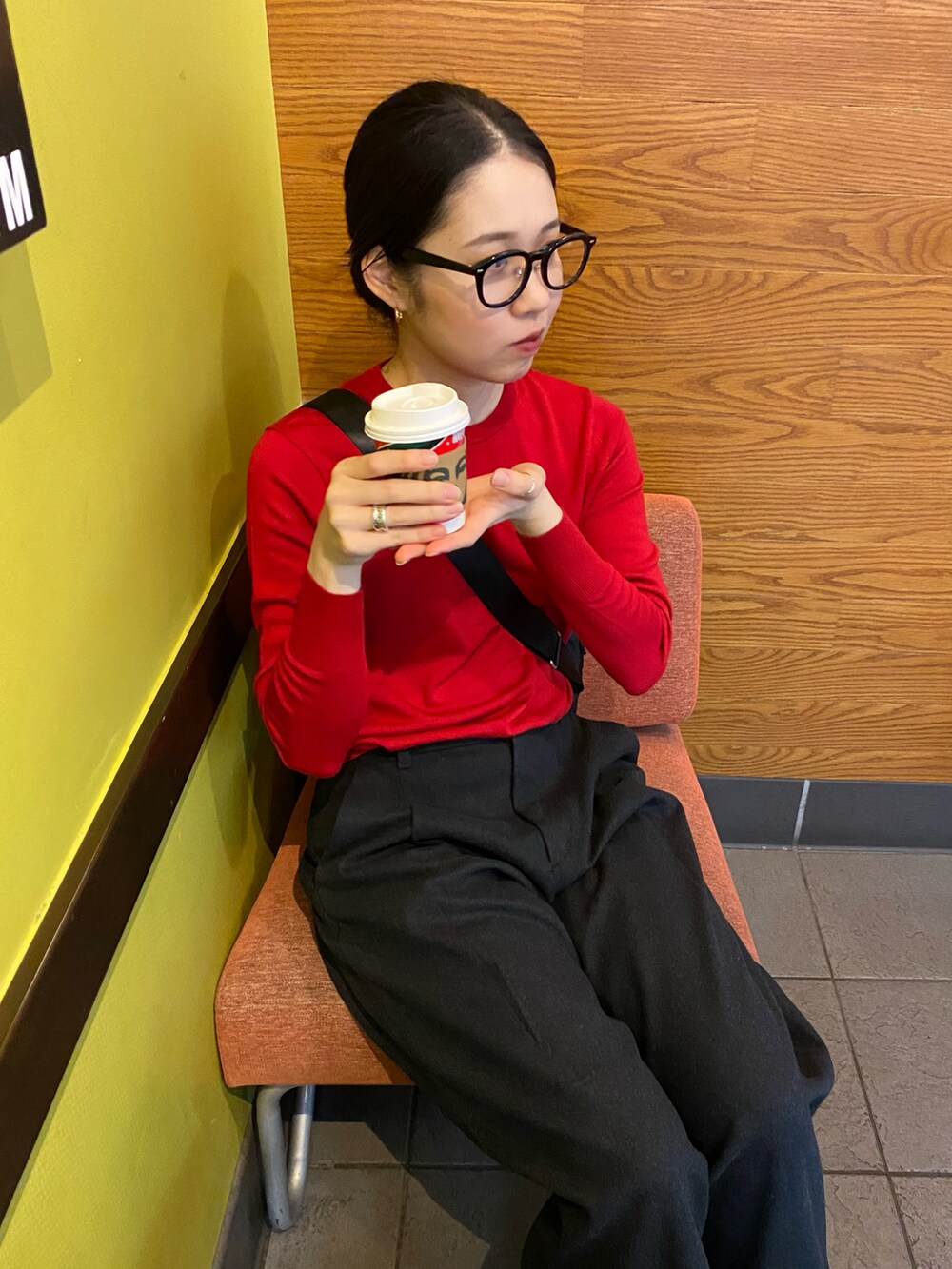 レッド系のニット/セーター、グレー系のパンツ、ブラック系のスニーカーを着用したレディースの秋コーディネートの3枚目の写真