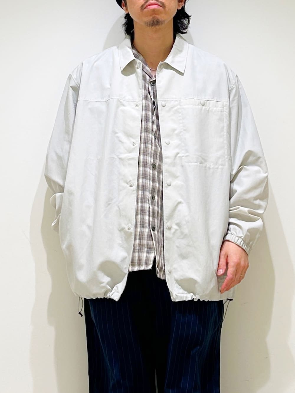 ホワイト系のその他アウター、ベージュ系のシャツ/ブラウス、ブルー系のその他パンツを着用したメンズの春コーディネートの6枚目の写真