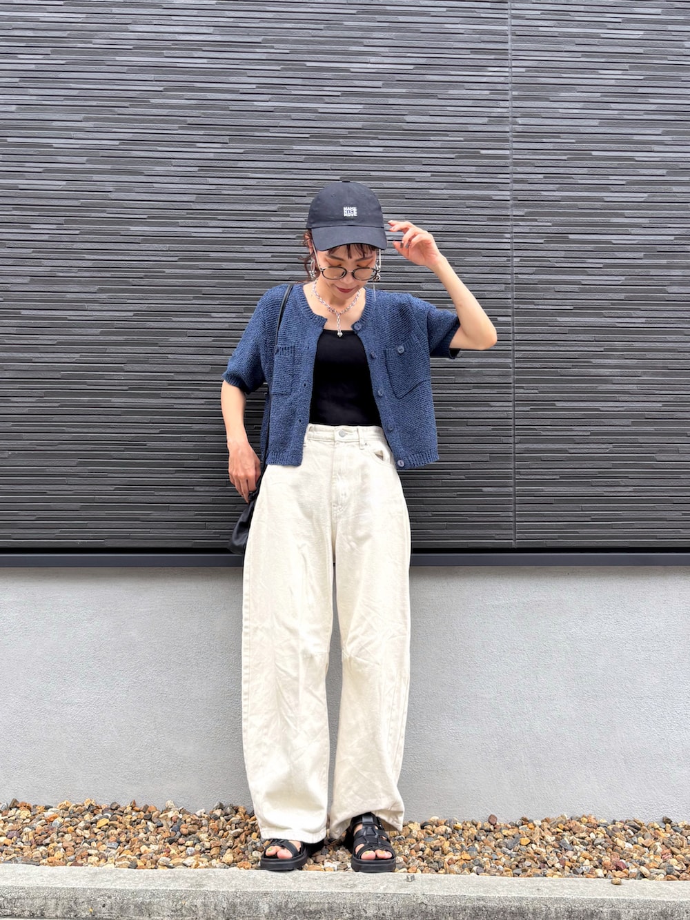 ブルー系のカーディガン/ボレロ、ベージュ系のデニムパンツ、ブラック系のバッグを着用したレディースの夏コーディネートの2枚目の写真