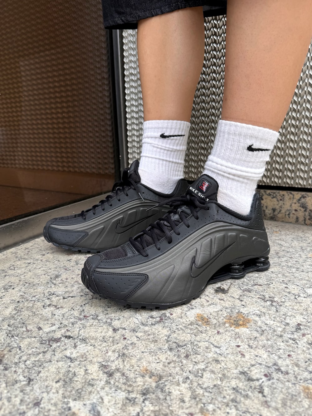 ブラック系のパーカー、ブラック系のデニムパンツ、ブラック系のスニーカーを着用したレディースの秋コーディネートの5枚目の写真