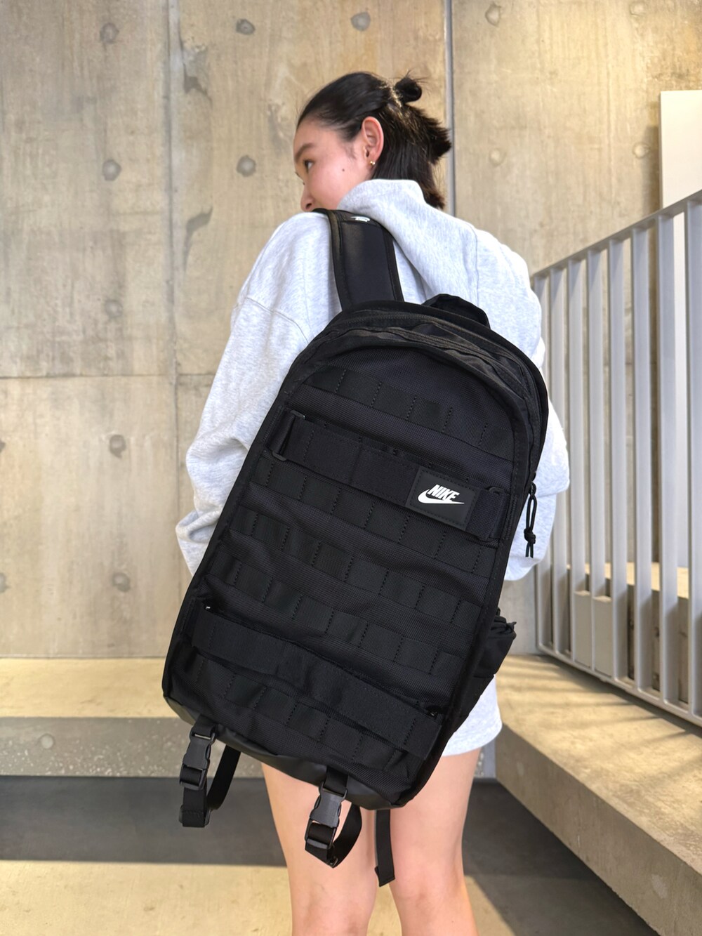 ブラック系のスニーカー、グレー系のパーカー、ブラック系のバックパック/リュックを着用したレディースの秋コーディネートの3枚目の写真