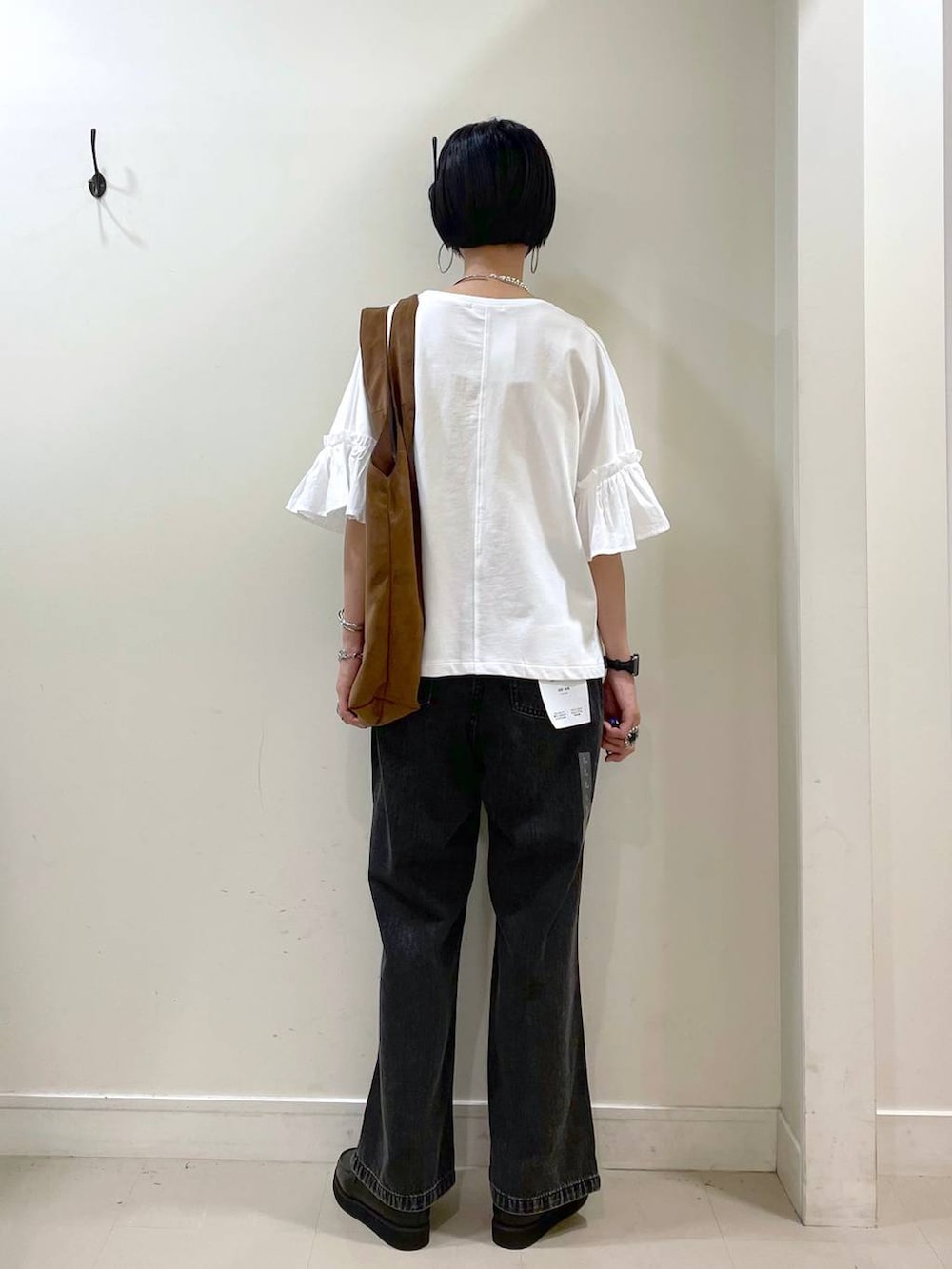 ブラック系のローファー、ブラック系のデニムパンツ、ベージュ系のトートバッグを着用したレディースの秋コーディネートの4枚目の写真
