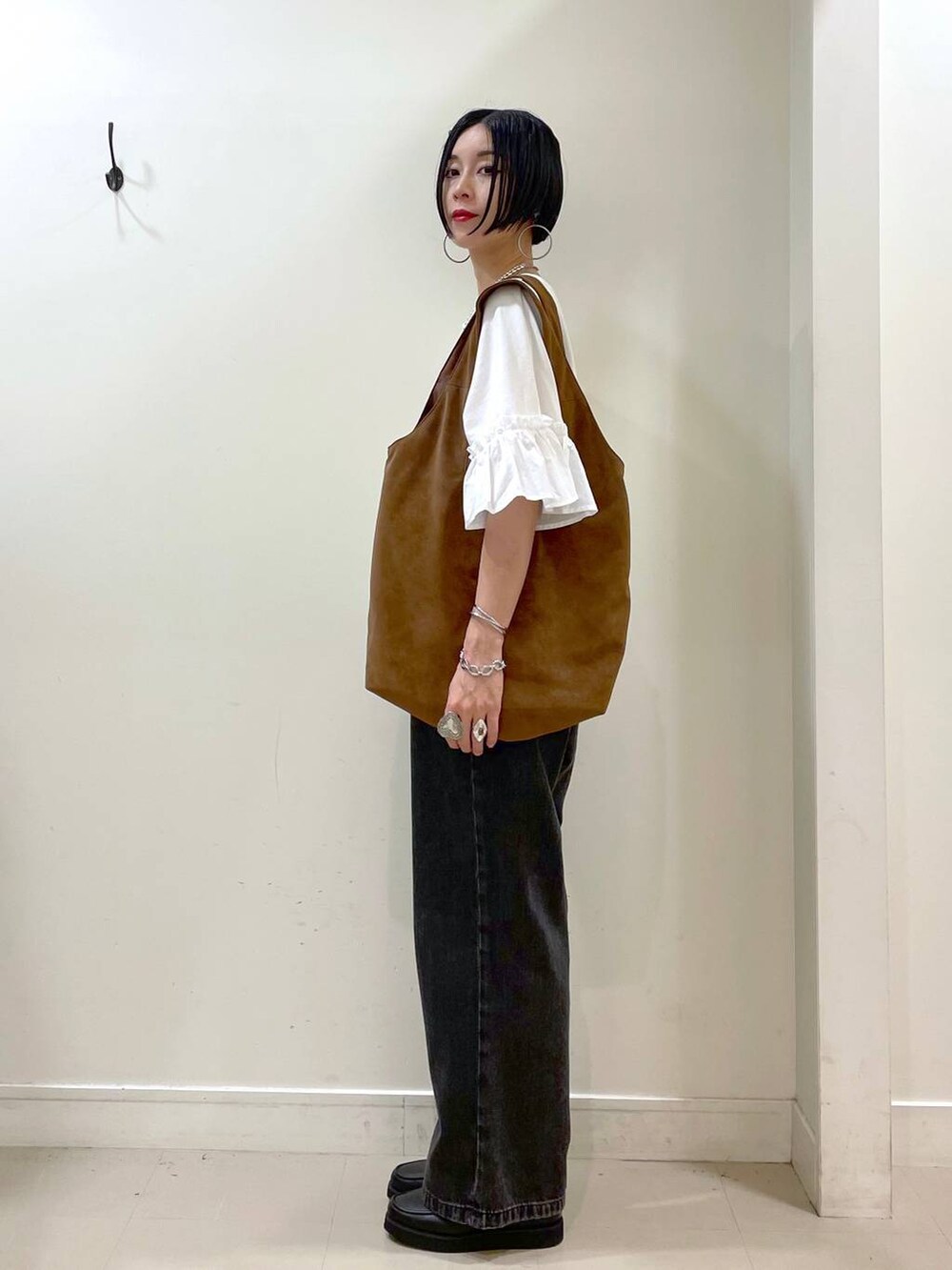 ブラック系のローファー、ブラック系のデニムパンツ、ベージュ系のトートバッグを着用したレディースの秋コーディネートの5枚目の写真