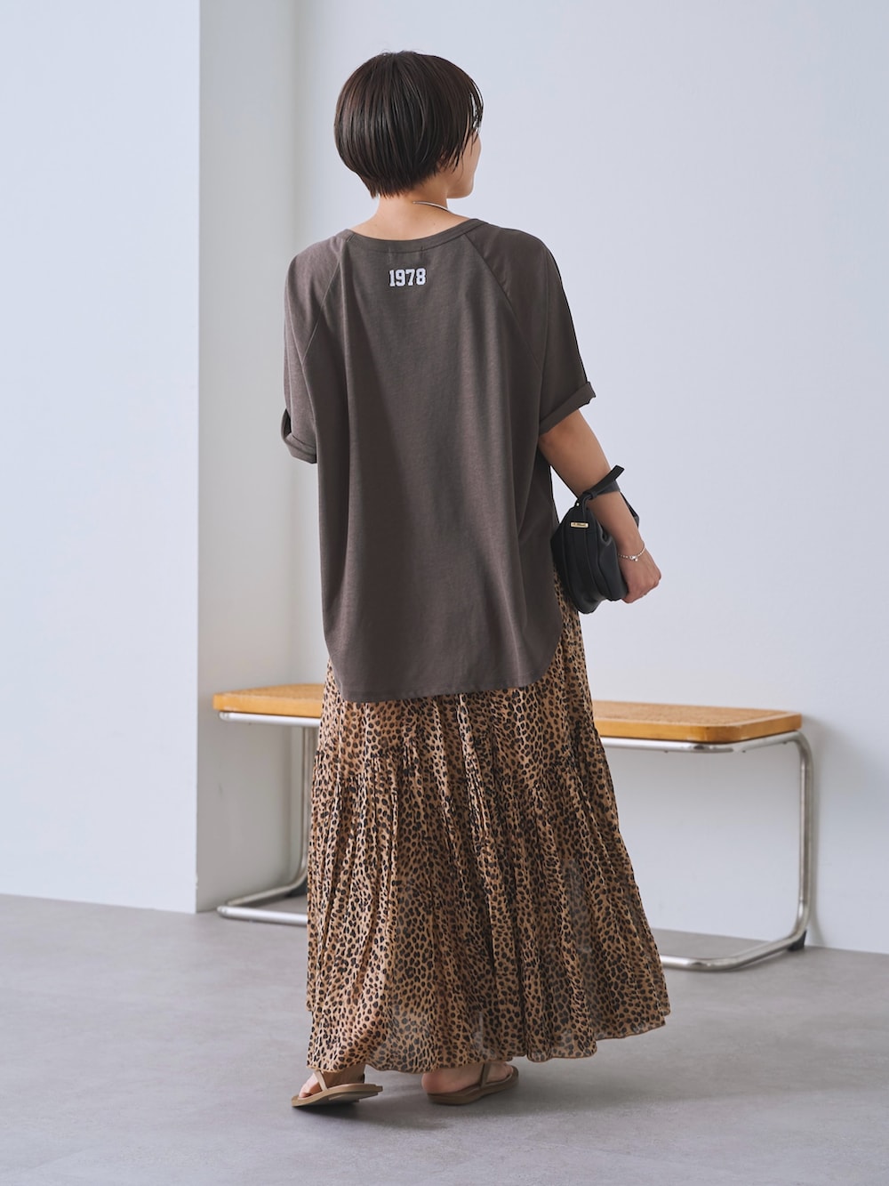 ベージュ系のスカート、ブラック系のショルダーバッグ、ブラウン系のTシャツ/カットソーを着用したレディースの春コーディネートの3枚目の写真