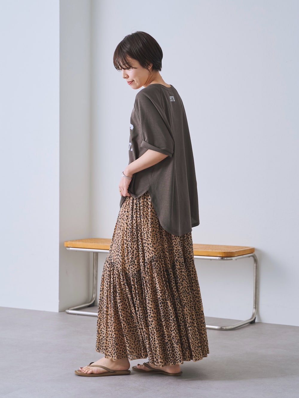 ベージュ系のスカート、ブラック系のショルダーバッグ、ブラウン系のTシャツ/カットソーを着用したレディースの春コーディネートの2枚目の写真
