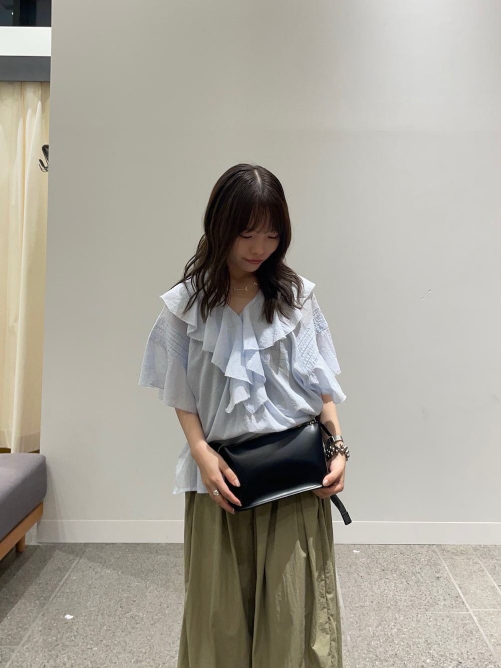 ブルー系のシャツ/ブラウス、ブラック系のボディバッグ/ウエストポーチ、ベージュ系のその他パンツを着用したレディースの夏コーディネートの2枚目の写真