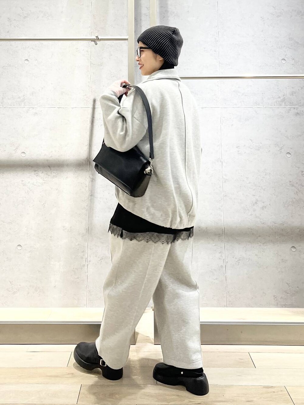 ブラック系のショルダーバッグ、グレー系のスウェットパンツ、ブラック系のサンダルを着用したレディースの春コーディネートの3枚目の写真