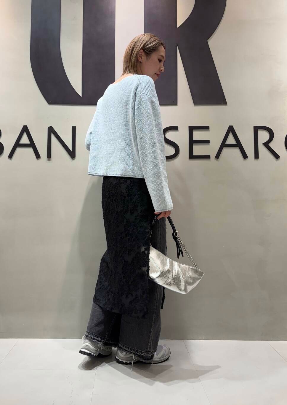 ブラック系のデニムパンツ、ブルー系のニット/セーター、グレー系のスニーカーを着用したレディースの冬コーディネートの2枚目の写真