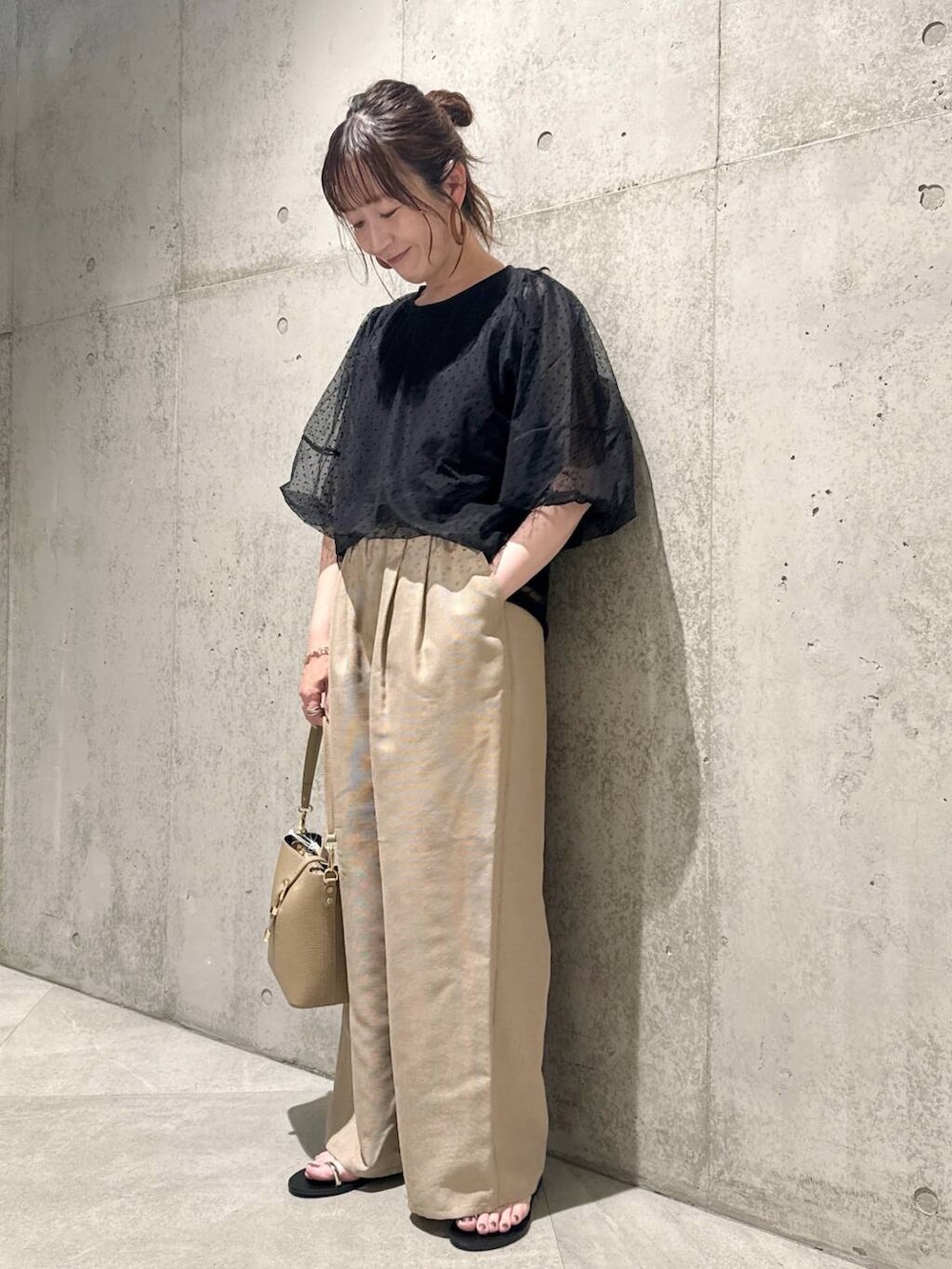 ベージュ系のショルダーバッグ、ブラック系のサンダル、ブラック系のTシャツ/カットソーを着用したレディースの夏コーディネートの3枚目の写真