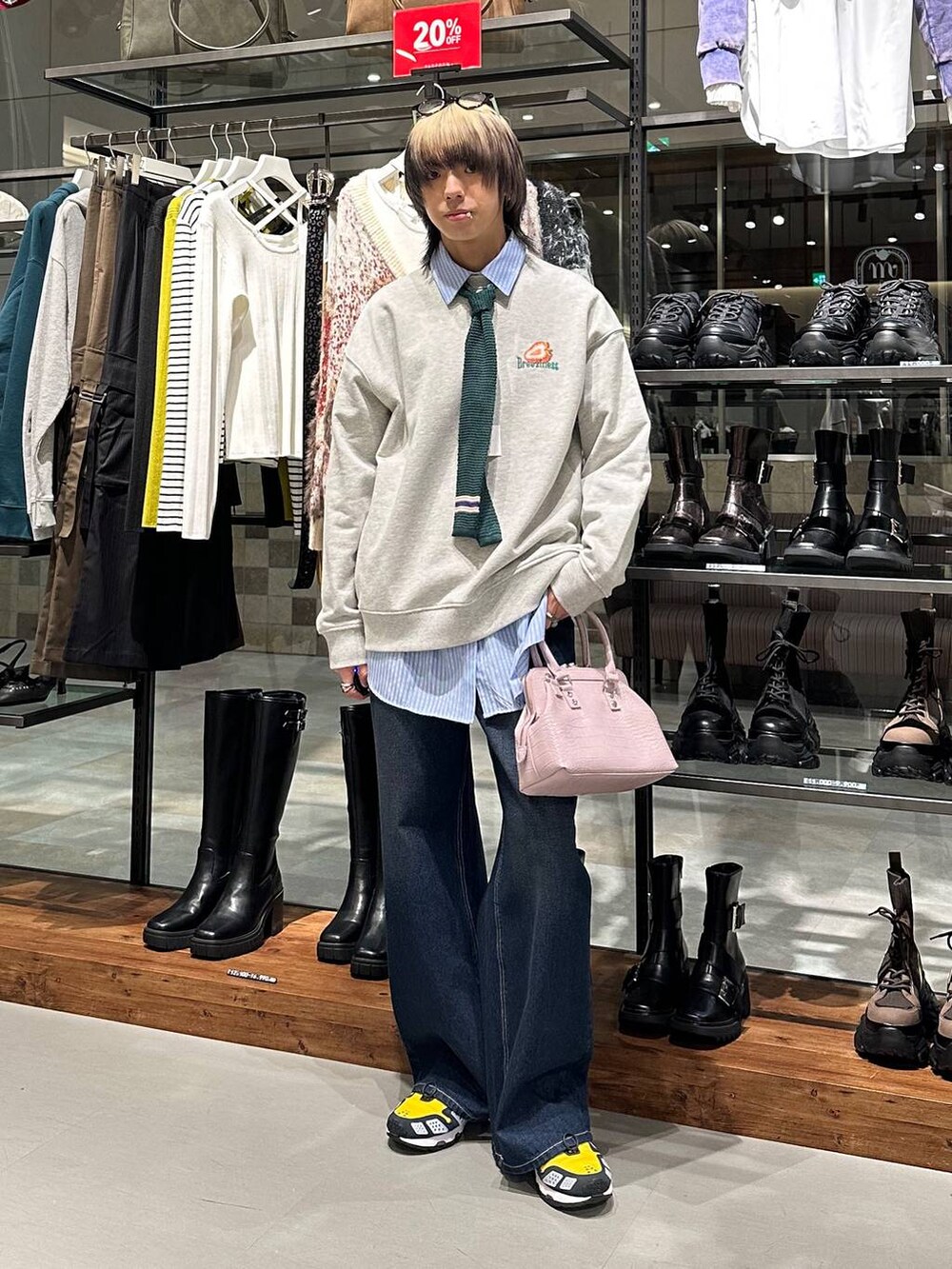 ブルー系のデニムパンツ、ピンク系のハンドバッグ、グレー系のスウェットを着用したメンズの冬コーディネートの2枚目の写真
