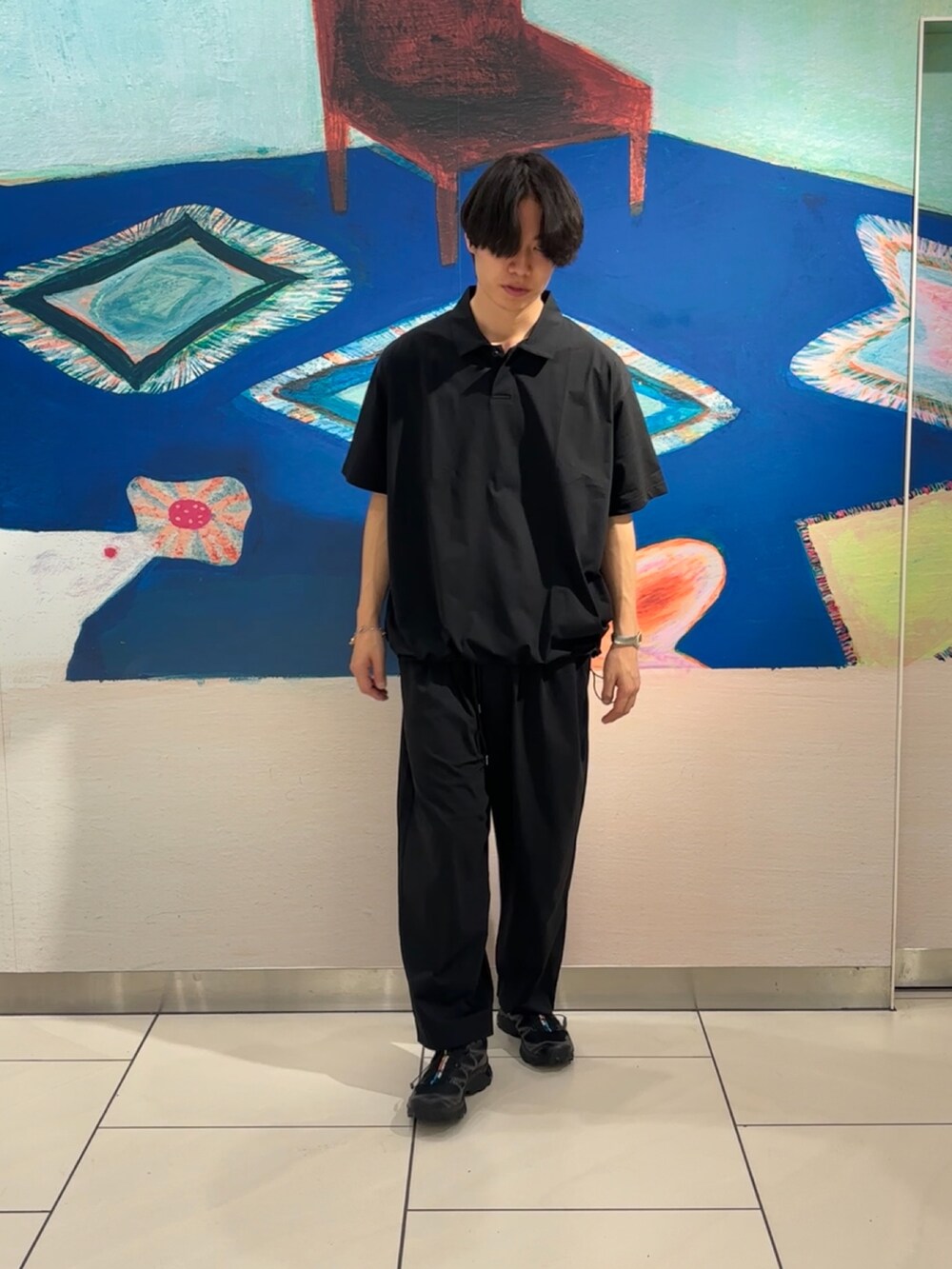 ブラック系のポロシャツ、ブラック系のその他パンツ、ブラック系のスニーカーを着用したメンズの春コーディネートの4枚目の写真