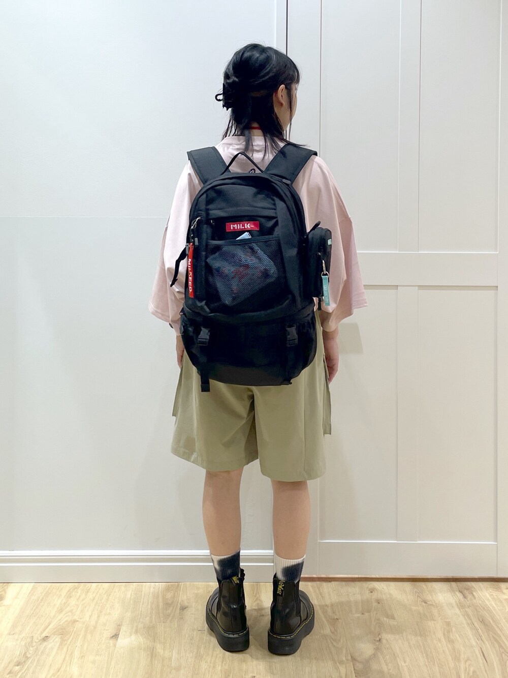 ピンク系のTシャツ/カットソー、ブラック系のブーツ、レッド系のバックパック/リュックを着用したレディースの夏コーディネートの3枚目の写真