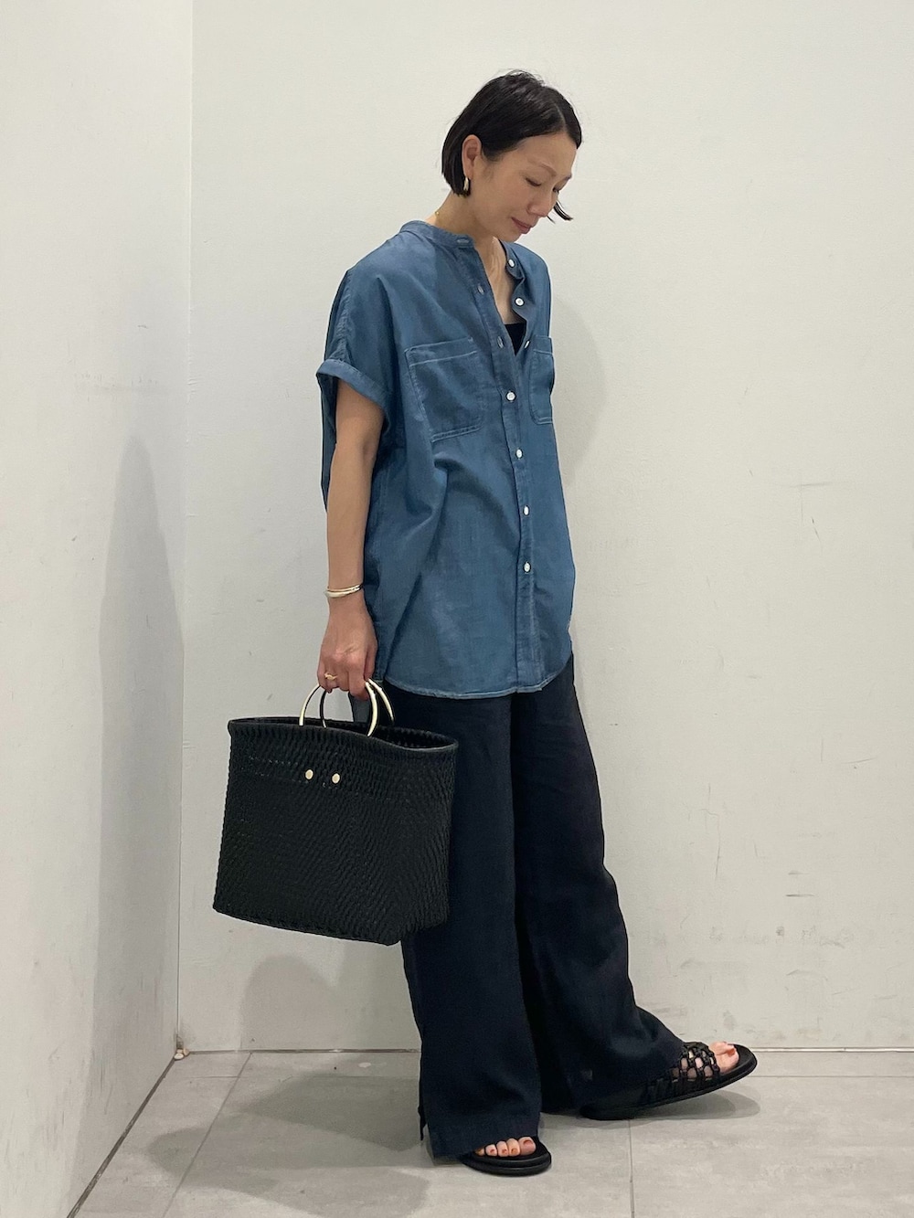 ブラック系のその他パンツ、ブルー系のシャツ/ブラウス、ブラック系のトートバッグを着用したレディースの夏コーディネートの3枚目の写真