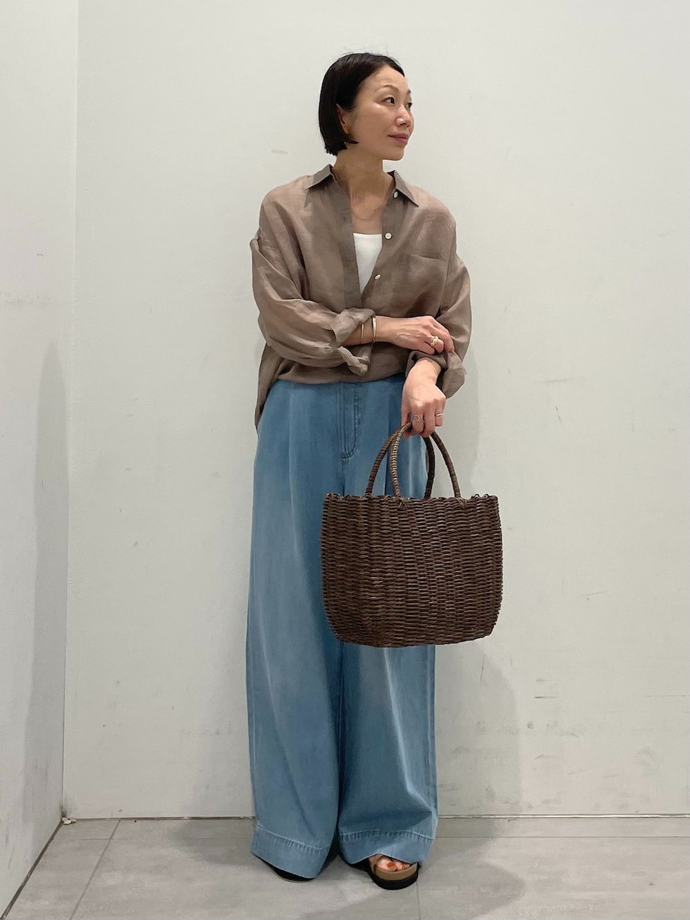 ブルー系のデニムパンツ、ブラウン系のシャツ/ブラウス、ホワイト系のタンクトップを着用したレディースの春コーディネートの7枚目の写真