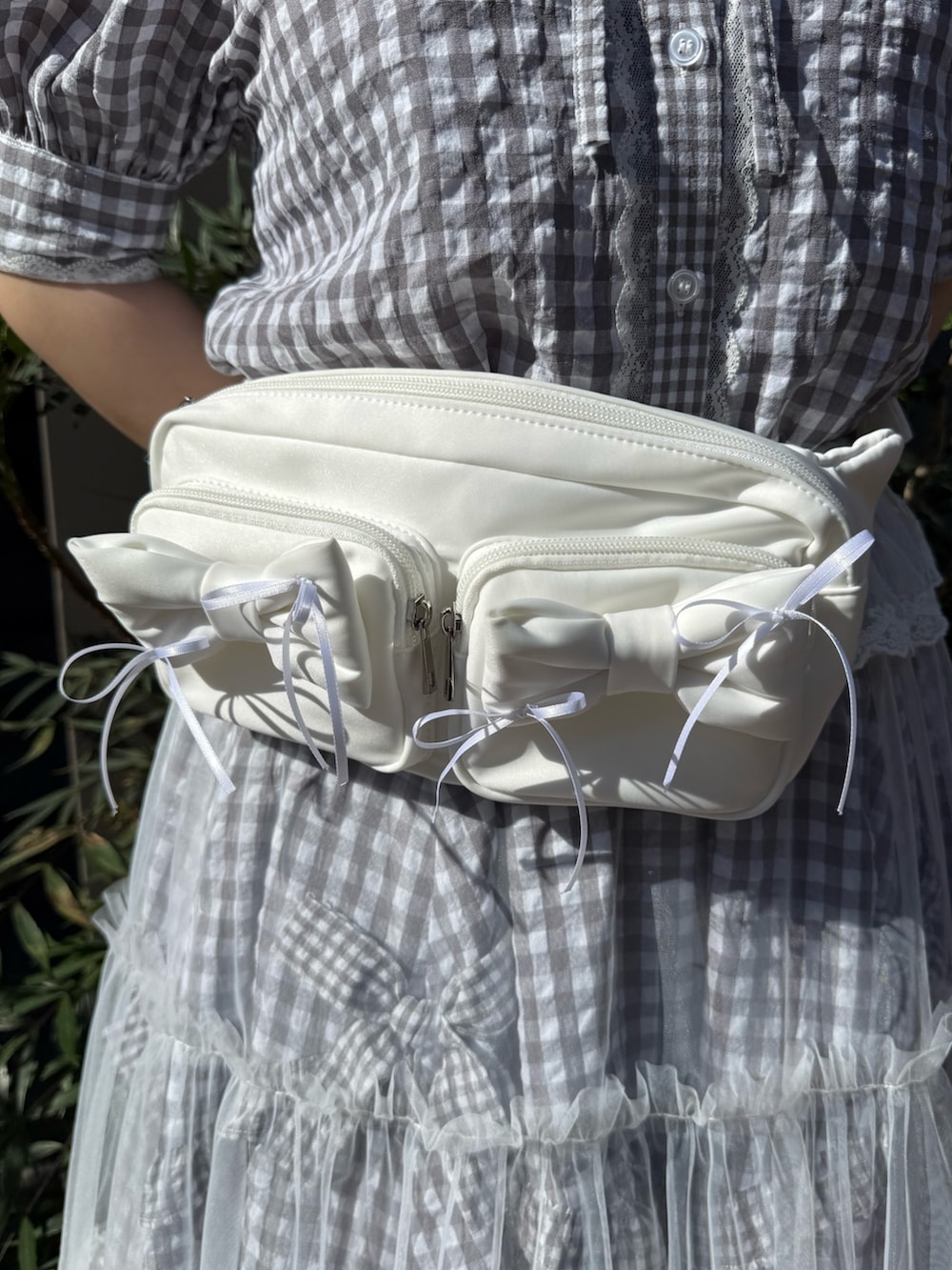 グレー系のシャツ/ブラウス、グレー系のスカート、ホワイト系のボディバッグ/ウエストポーチを着用したレディースの春コーディネートの6枚目の写真