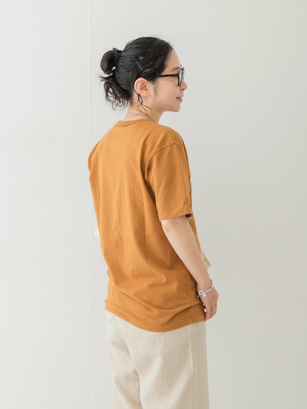 ベージュ系のその他パンツ、ブラウン系のサンダル、ブラウン系のトートバッグを着用したレディースの夏コーディネートの8枚目の写真