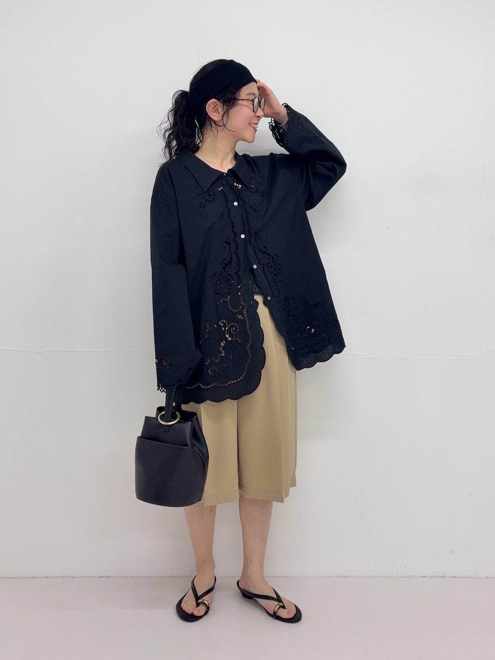 ブラック系のシャツ/ブラウス、ベージュ系のその他パンツ、ブラック系のハンドバッグを着用したレディースの春コーディネートの2枚目の写真